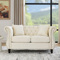 Causeuse en velours beige avec accoudoirs roulés et détails cloutés