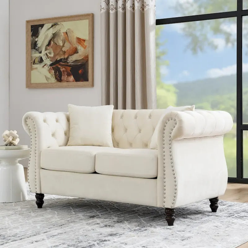 Causeuse en velours beige avec accoudoirs roulés et détails cloutés