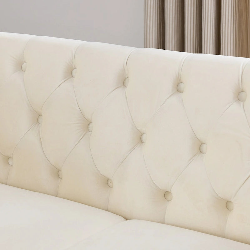 Causeuse en velours beige avec accoudoirs roulés et détails cloutés